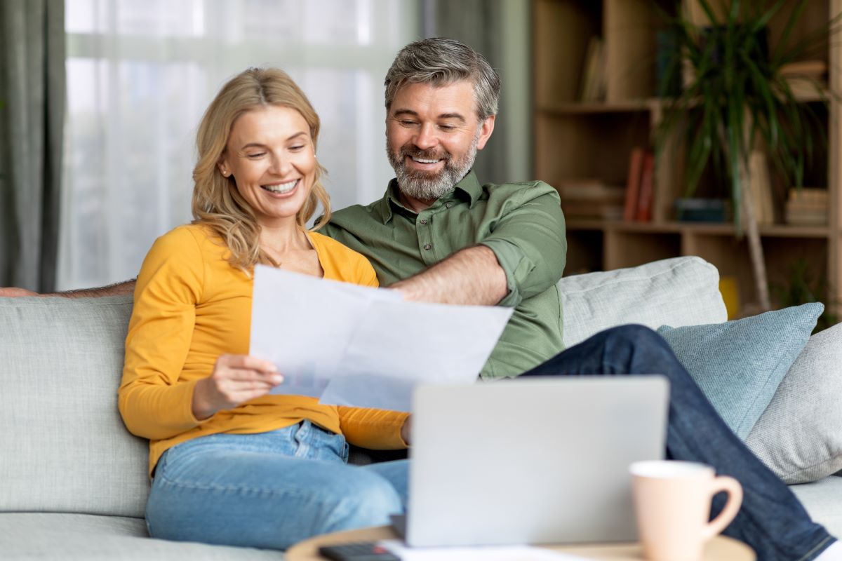 Couple reviewing documents sitting on a sofa